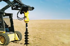Heavy duty auger attached to skid steer
